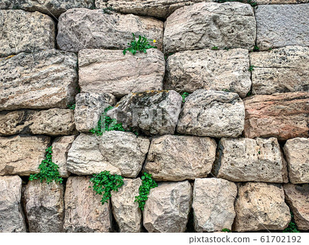 Ancient stone wall made of large limestones in Athens, Attica region in Greece. Huge antique blocks of stone piled up to form a wall. Photo. Ancient stone wall made of large limestones in Athens, Attica region in Greece. Huge antique blocks of stone piled up to form a wall. Photo. 61702192