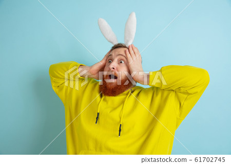 Easter bunny man with bright emotions on blue studio background Easter bunny man with bright emotions on blue studio background 61702745