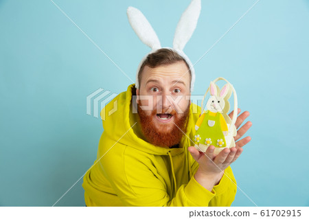 Easter bunny man with bright emotions on blue studio background Easter bunny man with bright emotions on blue studio background 61702915