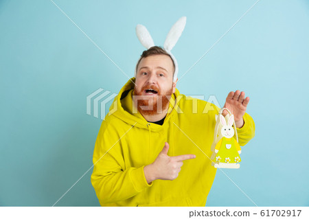 Easter bunny man with bright emotions on blue studio background Easter bunny man with bright emotions on blue studio background 61702917