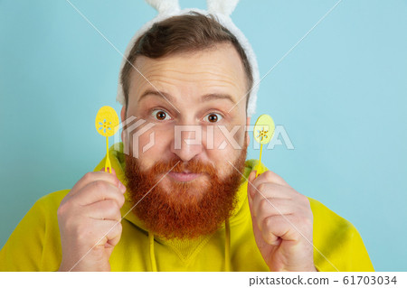 Easter bunny man with bright emotions on blue studio background 61703034