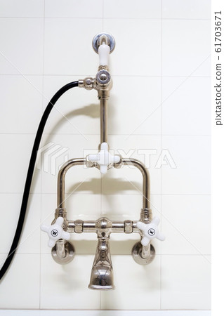 Beautiful shower bath with hot and cold water taps, white tile design wall, modern functionalism architecture Beautiful shower bath with hot and cold water taps, white tile design wall, modern functionalism architecture 61703671