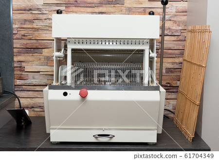 Close-up of automatic bread-slicer machine indoors 61704349