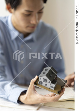 A first-class architect of a design office examining a floor plan while checking the Building Standard Law at home renovation A first-class architect of a design office examining a floor plan while checking the Building Standard Law at home renovation 61705360