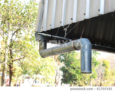 Closeup of rain gutters and roof gutters Made of zinc on the background of an outdoor green tree with bright sunlight 61705585