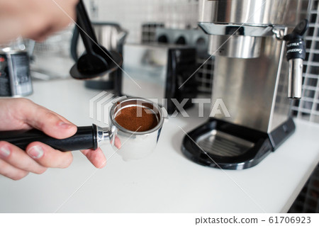 Guy prepare delicious aromatic coffee in a coffee 61706923