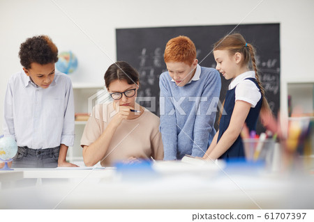 Teacher checking the work of students 61707397