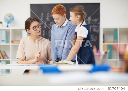 Teacher giving a task to children Teacher giving a task to children 61707404