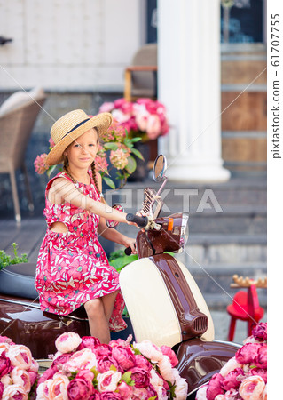 Adorable little girl in hat on the moped outdoors 61707755