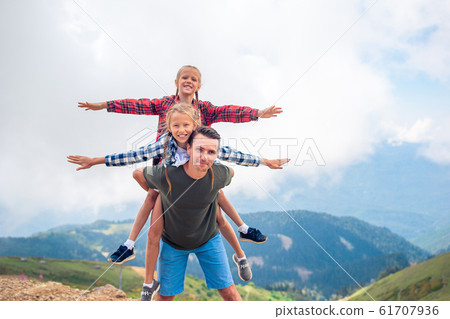 Beautiful kids and happy man in mountains in the background of fog 61707936