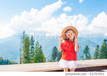 Beautiful happy little girl in mountains in the background of fog 61707952