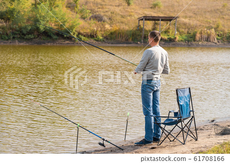 Man relaxing and fishing by lakeside a 61708166