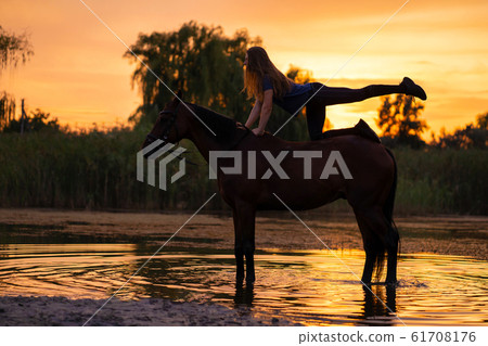 Silhouetted a slender girl practicing yoga on Silhouetted a slender girl practicing yoga on 61708176