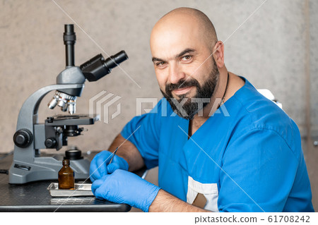 Male laboratory assistant examining biomaterial Male laboratory assistant examining biomaterial 61708242