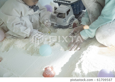 Children having fun playing in the flour playroom 61709587