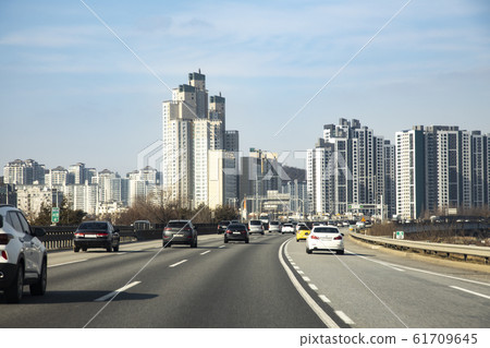 Cars on the road and city buildings 61709645