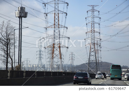 高速公路周圍的巨大輸電塔 高速公路周圍的巨大輸電塔 61709647
