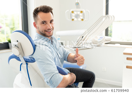 Man showing thumbs up at the dental clinic Man showing thumbs up at the dental clinic 61709940