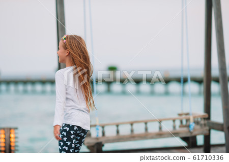 Little adorable girl playing on beach with ball Little adorable girl playing on beach with ball 61710336
