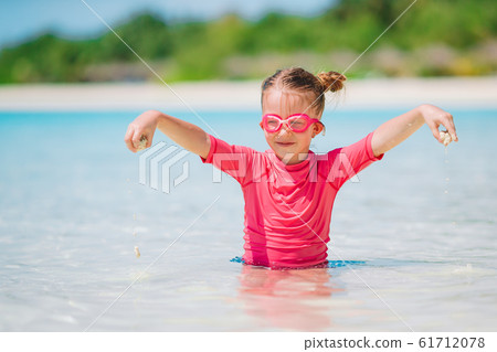 Little adorable girl playing on beach with ball 61712078