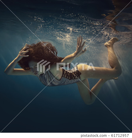 The girl actively swims underwater 61712957