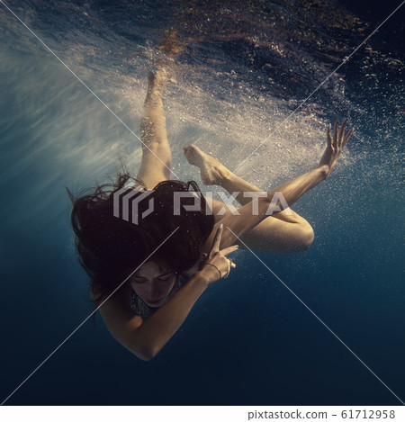 The girl actively swims underwater The girl actively swims underwater 61712958