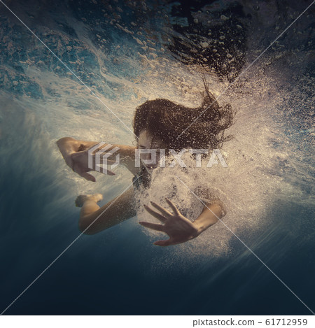 The girl actively swims underwater The girl actively swims underwater 61712959