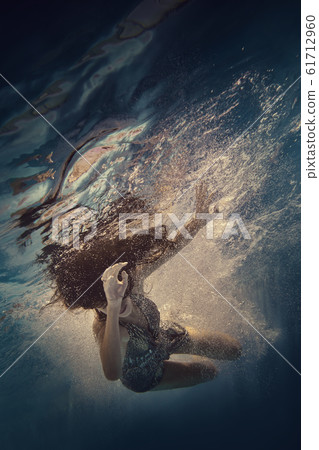 The girl actively swims underwater The girl actively swims underwater 61712960