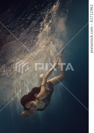 The girl actively swims underwater The girl actively swims underwater 61712962