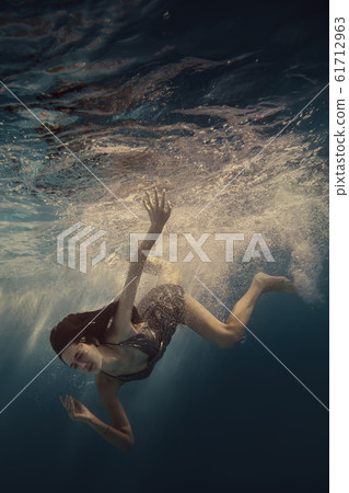 The girl actively swims underwater The girl actively swims underwater 61712963