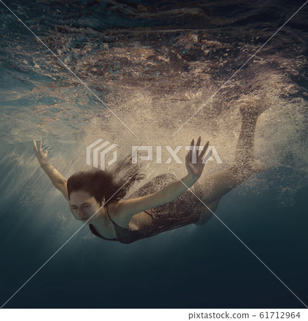 The girl actively swims underwater The girl actively swims underwater 61712964