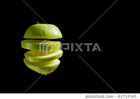 Sliced apple with water droplets over black background Sliced apple with water droplets over black background 61714165