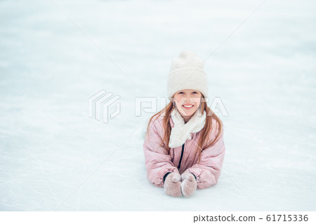 Little adorable girl sitting on ice with skates after fall Little adorable girl sitting on ice with skates after fall 61715336