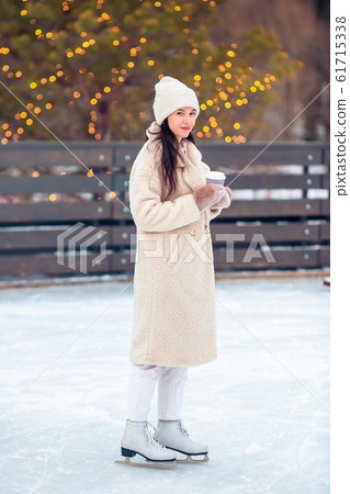 Smiling young girl skating on ice rink outdoors Smiling young girl skating on ice rink outdoors 61715338