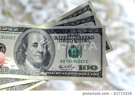 Girl holding money bill of 300 dollars on background of sea ocean Girl holding money bill of 300 dollars on background of sea ocean 61715859