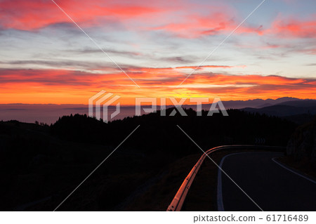 Dramatic red sky with reflections on guard rail Dramatic red sky with reflections on guard rail 61716489