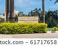 AGIA NAPA, CYPRUS - MAY 26, 2019: the Nissi Beach Resort Hotel signboard, Ayia Napa.This sign is set in the bushes, on the background of palm trees. 61717658