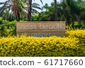 AGIA NAPA, CYPRUS - MAY 26, 2019: the Nissi Beach Resort Hotel signboard, Ayia Napa.This sign is set in the bushes, on the background of palm trees. 61717660