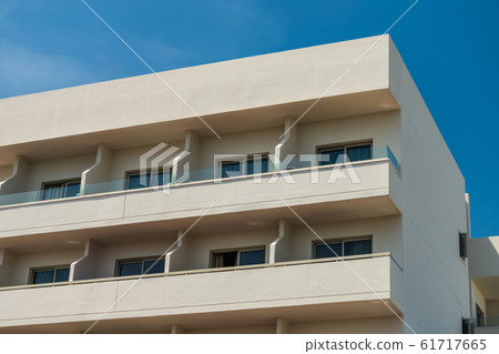 Modern new building with open balconies against the summer blue sky 61717665