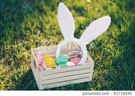 Wooden box with multicolour eggs and bunny ears Wooden box with multicolour eggs and bunny ears 61719440