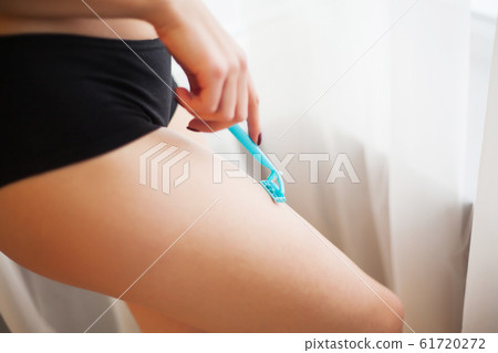 Caucasian woman shaving legs with razor at home 61720272