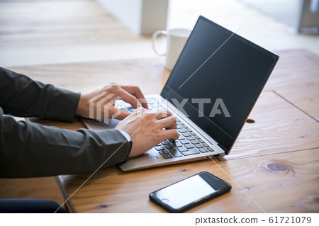 Men's hand operating a laptop 61721079