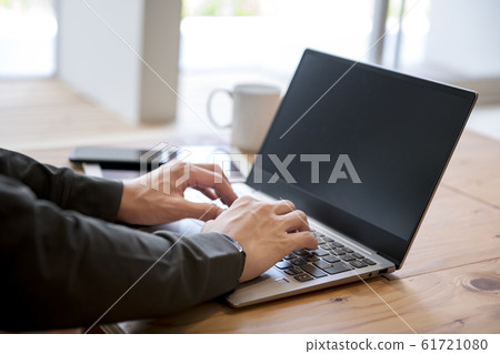 Men's hand operating a laptop 61721080