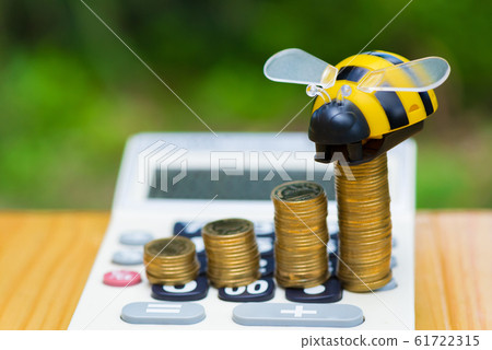 Growing coins and calculator on wood table with 61722315