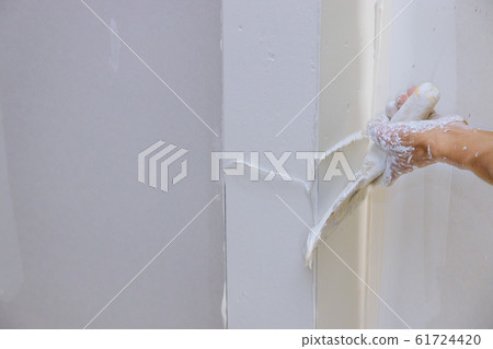 Renovation the wall with putty plasterer spreading 61724420