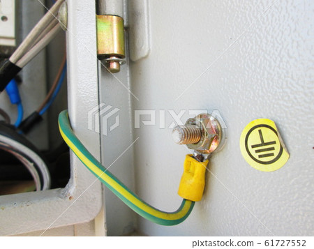 Yellow-green ground cable in a metal box The gray breaker box has a ground cable built in to protect against electric shock and has a yellow sticker with a ground symbol on the lid. 61727552