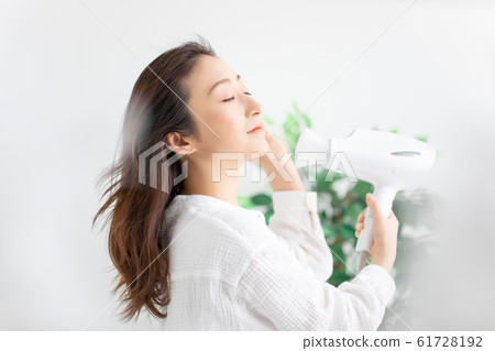 一個女人用吹風機 61728192
