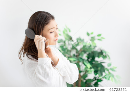 A woman stroking her hair 61728251