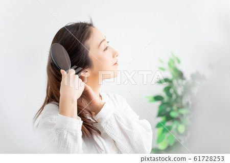 A woman stroking her hair 61728253