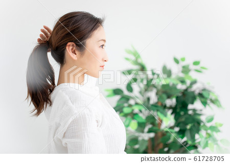 Woman tying hair Woman tying hair 61728705